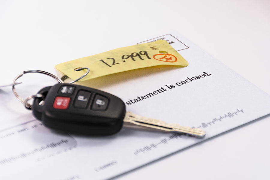 car keys on a bill of sale for a pre-owned car