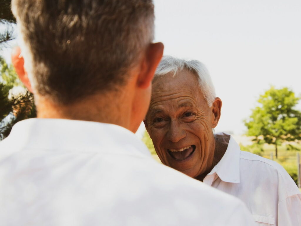 an older man talking outside to a younger man