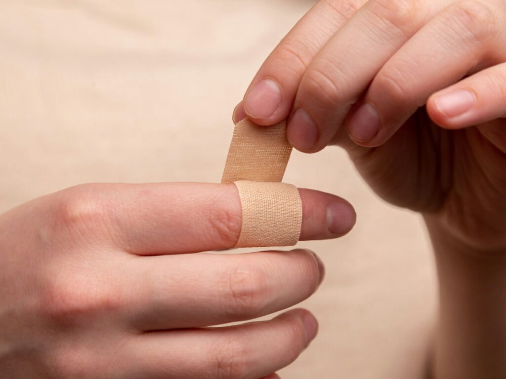 a person with hemophilia wraps their cut finger in a bandage