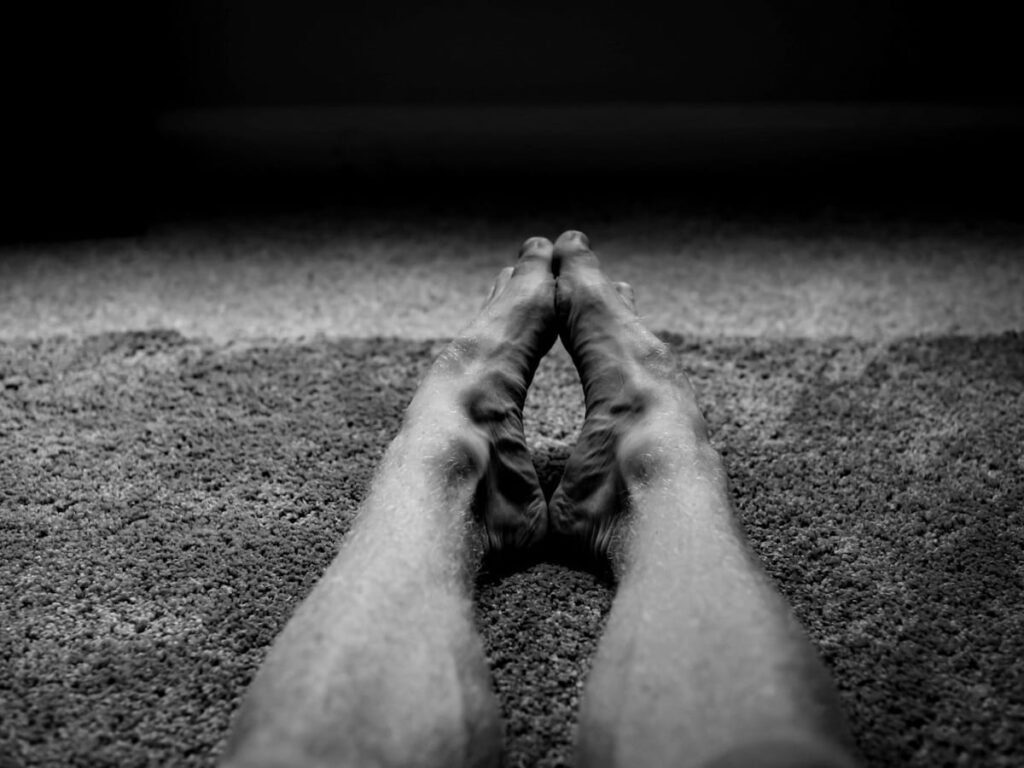 a black and white image of legs and feet