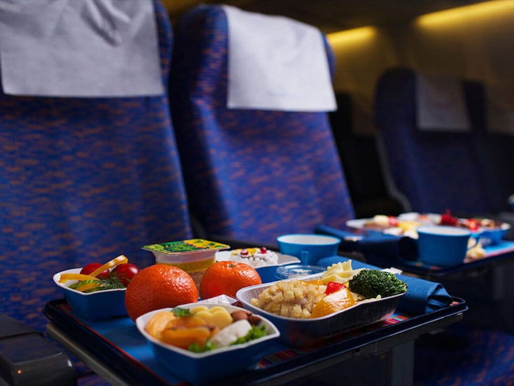 business class airplane seats with full meals on the tray table