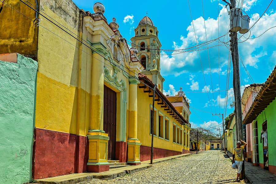 a street in cuba lined with colorful buildings