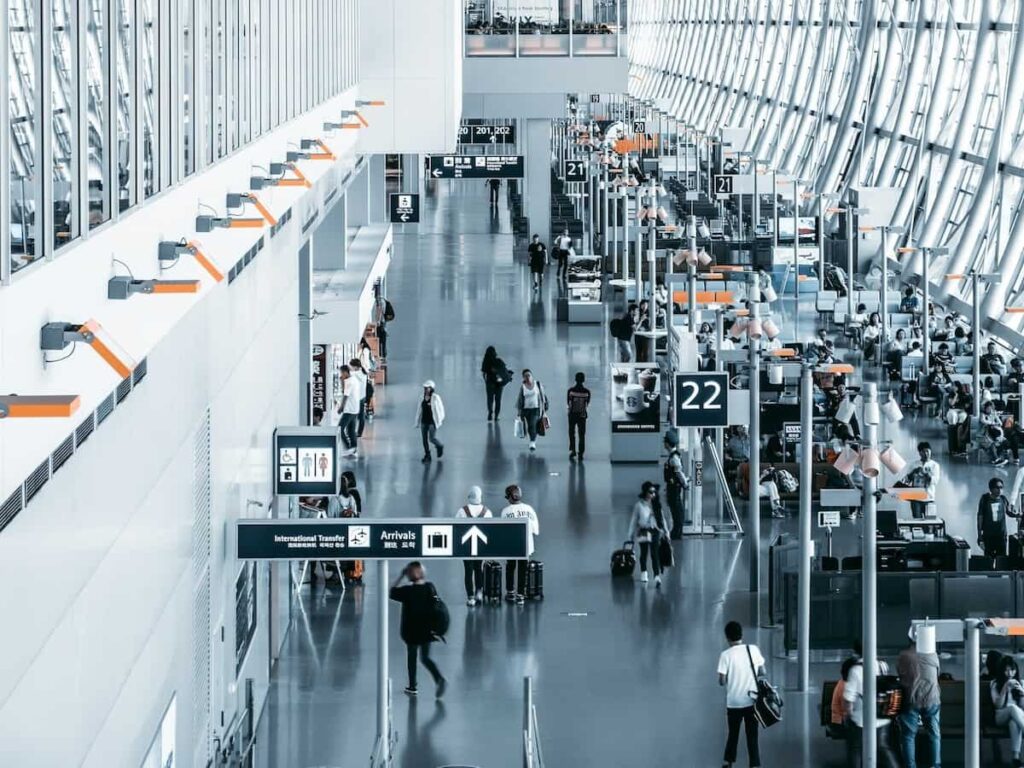 travelers walk through an airport gate area
