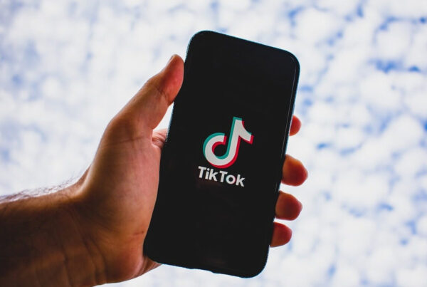 a man holding a phone with the tiktok logo on it