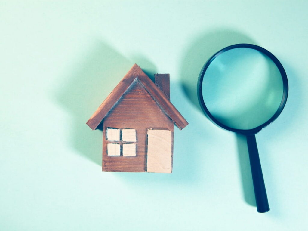 a house and a magnifying glass signifying a not well talked about mortgage clause